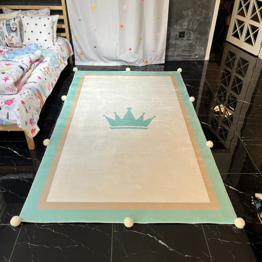 Ponpon detaylı krem, bej ve yeşil bir çocuk halısı, odanın içinde zemin üzerine serilmiş.