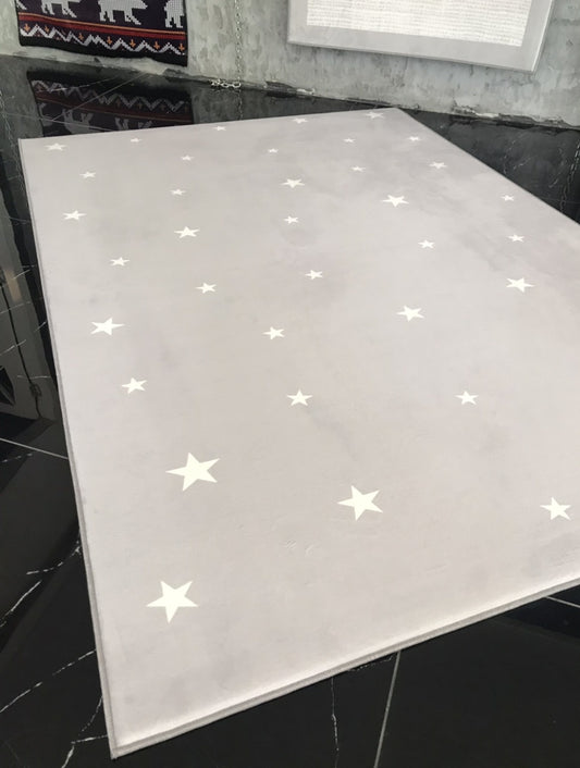 Halı Vagonu HV383 yıldız desenli gri çocuk odası halısı, yumuşak dokusu ile dikkat çekiyor. Zeminde dağınık yerleştirilmiş beyaz yıldızlar ile modern bir görünüm sunuyor.