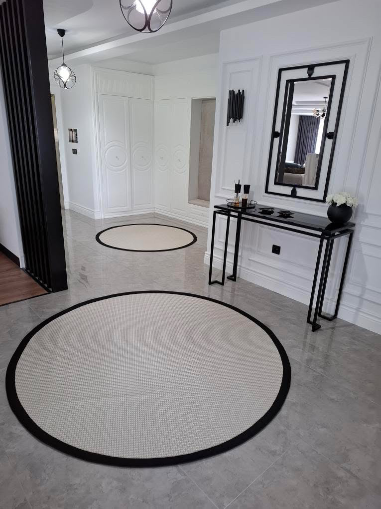 HALI VAGONU Siyah Krem Kumaş Bordürlü Sisal Halı - El yapımı, dayanıklı, modern tasarım. Daire görünümünde yerleştirilmiş kremsi renklerdeki halılar ve şık dekorasyonla birlikte, siyah kumaş bordürlü krem sisal halı her mekanı zarif kılar. Bu dayanıklı sisal halı, ofisler ve modern salonlar için mükemmel bir tercihtir.