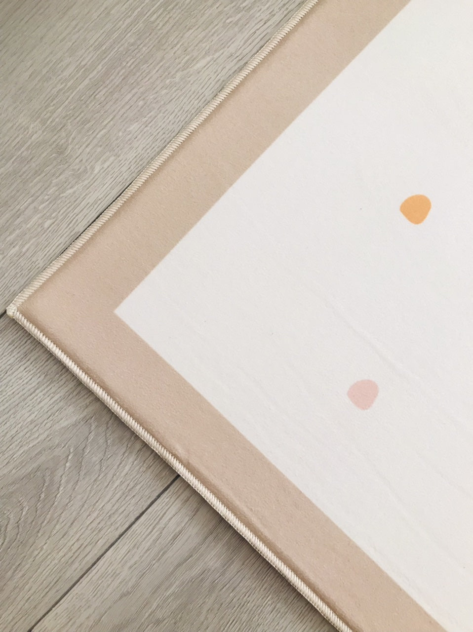 Halı kenarının detayını gösteren, narin pastel renklerdeki desenin ve pürüzsüz yüzeyin yakın plan görüntüsü.