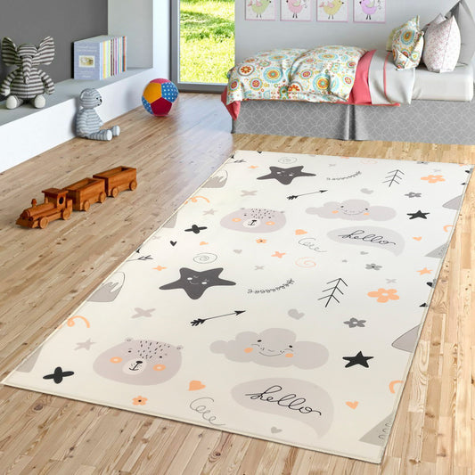 Çocuk odasında yer alan sevimli desenli halı, üstünde bulut, ayı ve yıldız figürleri var. Halının etrafında oyuncaklar ve renkli bir dekor mevcut.