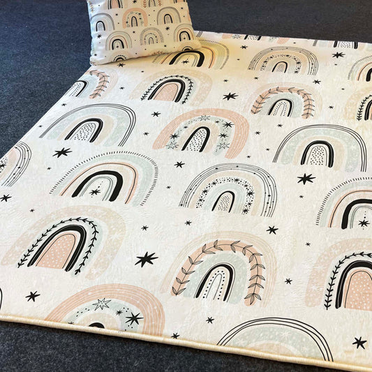 Gökkuşağı desenli halı, mekanın içinde serili, çocuk dostu bir ortam yaratıyor.