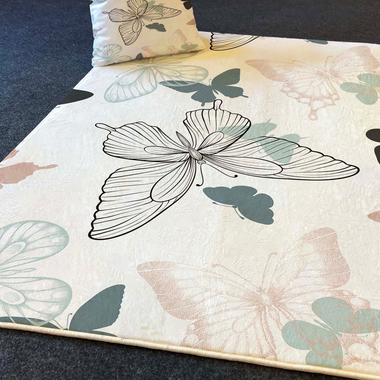 Halı Vagonu HV335 Kelebekli çocuk odası halısı, büyük kelebek ve küçük kelebek figürleriyle soft pastel tonlarında tasarlandı. Halının üst kısmında dekoratif bir yastık yer alıyor.