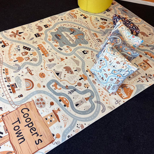 Çocuk odasında yer alan Cooper's Town temalı halı üzerinde, nehir ve yollarla biçimlendirilmiş eğlenceli desenler. Sarı bir oturma bölümü ve çeşitli yastıklarla ortamı renklendiriyor.