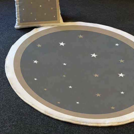 Gri yıldızlı halı ve uyumlu renkte bir yastık, yuvarlak bir şekilde düzenlenmiş, arka planda karizmatik bir zemin.