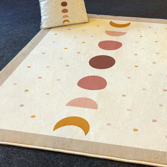 Pastel renklerdeki yarım daire ve daire desenlerine sahip halı, yanında eşleşen yastık ile birlikte görüntüleniyor.