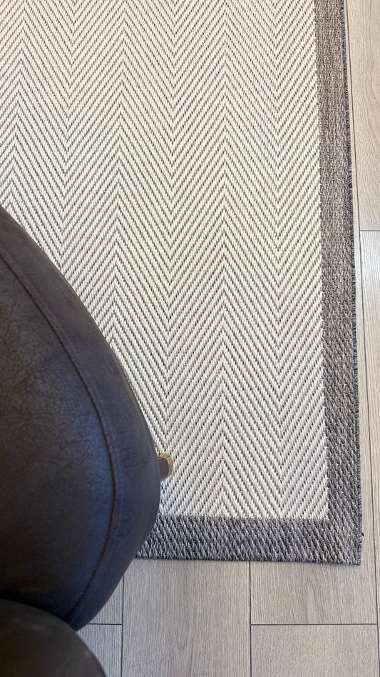 Yıkanabilir Siesta Sisal halı bir koltuğun bitişiğinde konumlandırılmış, sıcak bir şömine arka planda.