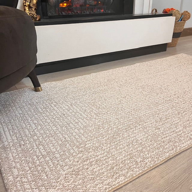 Elit Sisal halı, oturma alanında bir koltuğun önünde yer alıyor.