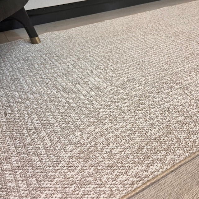 Elit Sisal halının yüzey dokusu ve desen detayları, odadaki minimal tasarıma uyum sağlamakta.