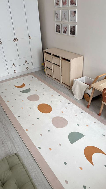 Modern bir çocuk odasında Bohem stili halı, pastel tonlardaki daireler ve ay şekilleriyle suslanmış.