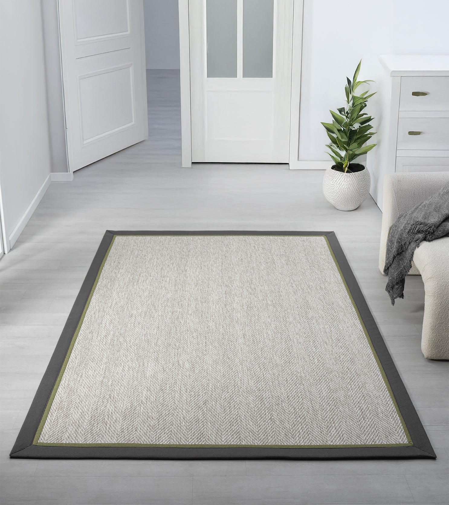 Modern bir oturma odasında yer alan sisal halı, minimalist tasarımı ve şık bordürü ile mekanın ortasında serili.