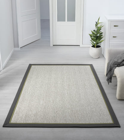 Modern bir oturma odasında yer alan sisal halı, minimalist tasarımı ve şık bordürü ile mekanın ortasında serili.