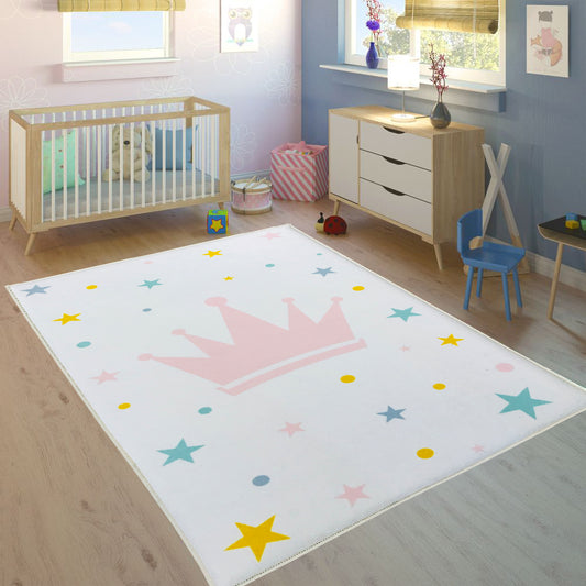 Renkli taçlı yıldızlı çocuk odası halısı, beyaz zemin üzerinde pembe bir taç ve çeşitli renkli yıldız ve noktalarla tasarlanmış, çocuk odasına sevimli bir görünüm katıyor.