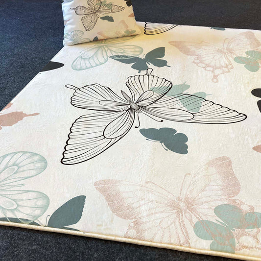 Halı Vagonu HV335 Kelebekli çocuk odası halısı, büyük kelebek ve küçük kelebek figürleriyle soft pastel tonlarında tasarlandı. Halının üst kısmında dekoratif bir yastık yer alıyor.