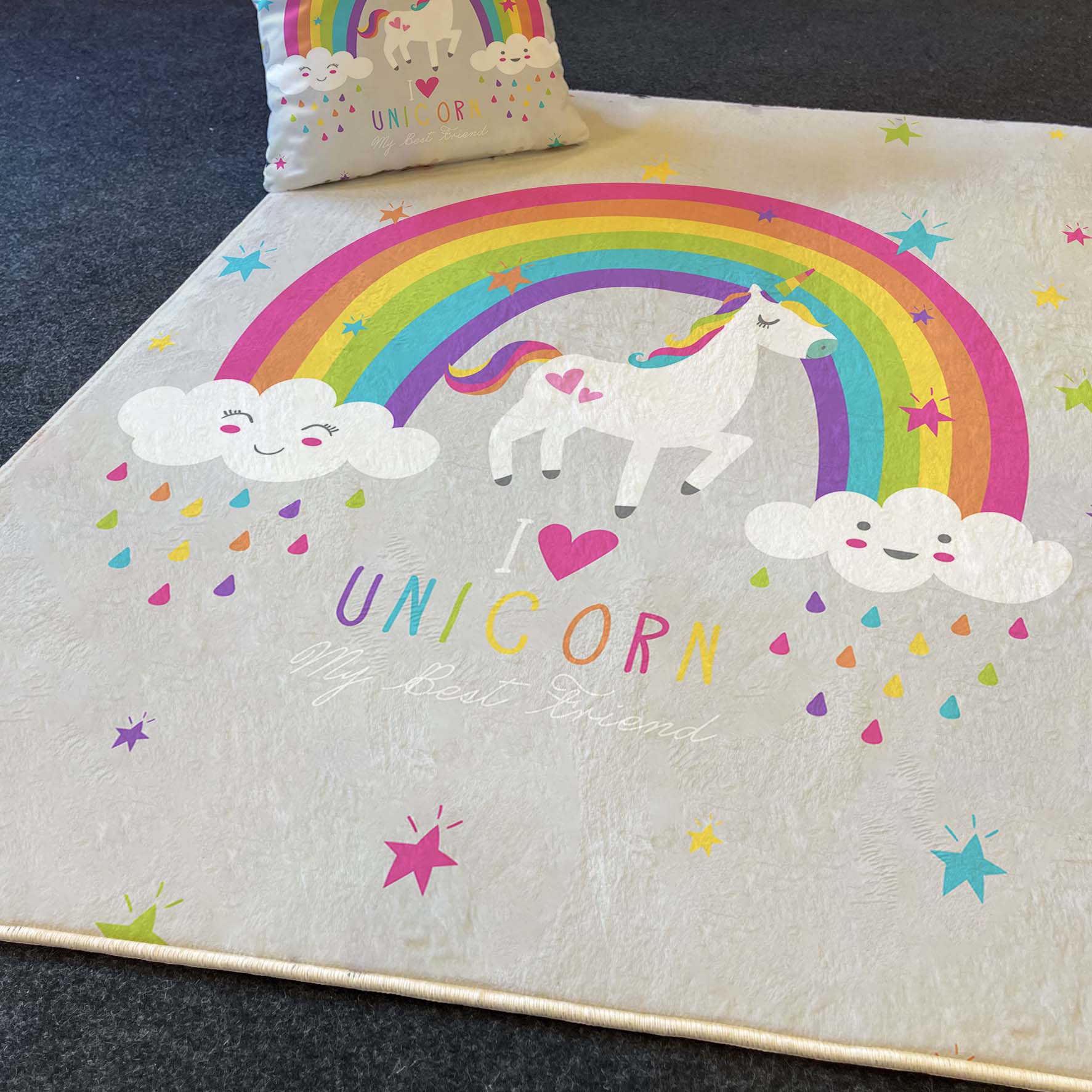 Renkli unicorn temalı halı, üzerinde gökkuşağı ve mutlu bulutlar ile birlikte 'I love UNICORN' yazısı.