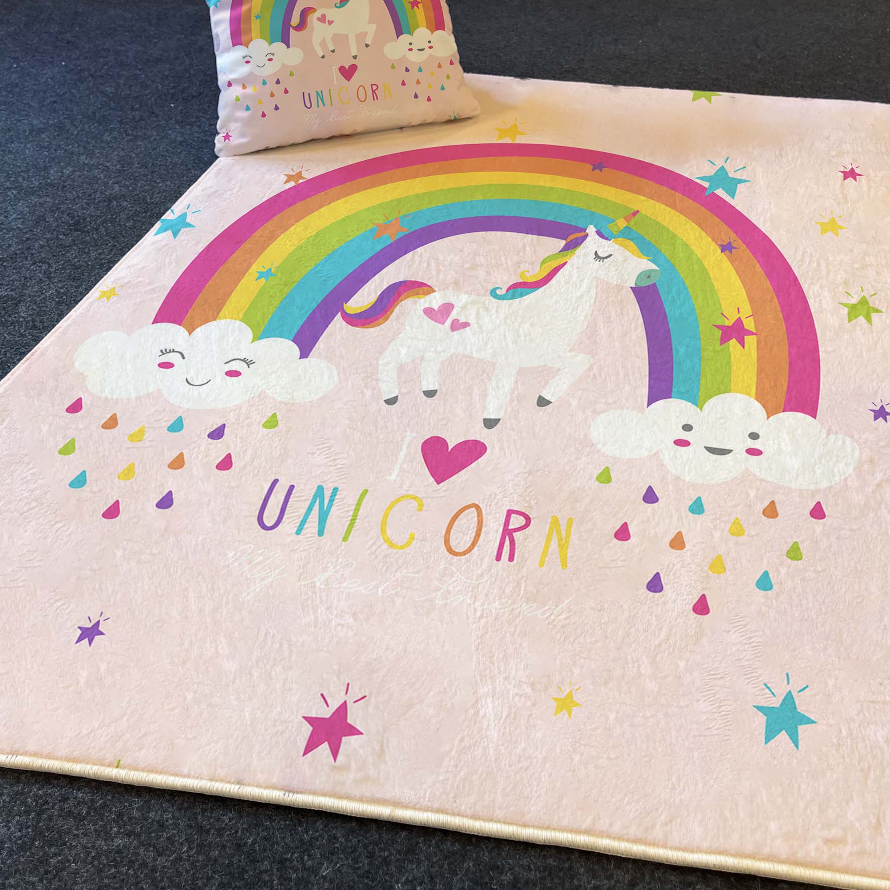 Unicorn temalı halı üzerinde sevimli bulutlar, yağmur damlaları ve yıldızlarla süslenmiş, odanın neşeli havasını tamamlıyor.