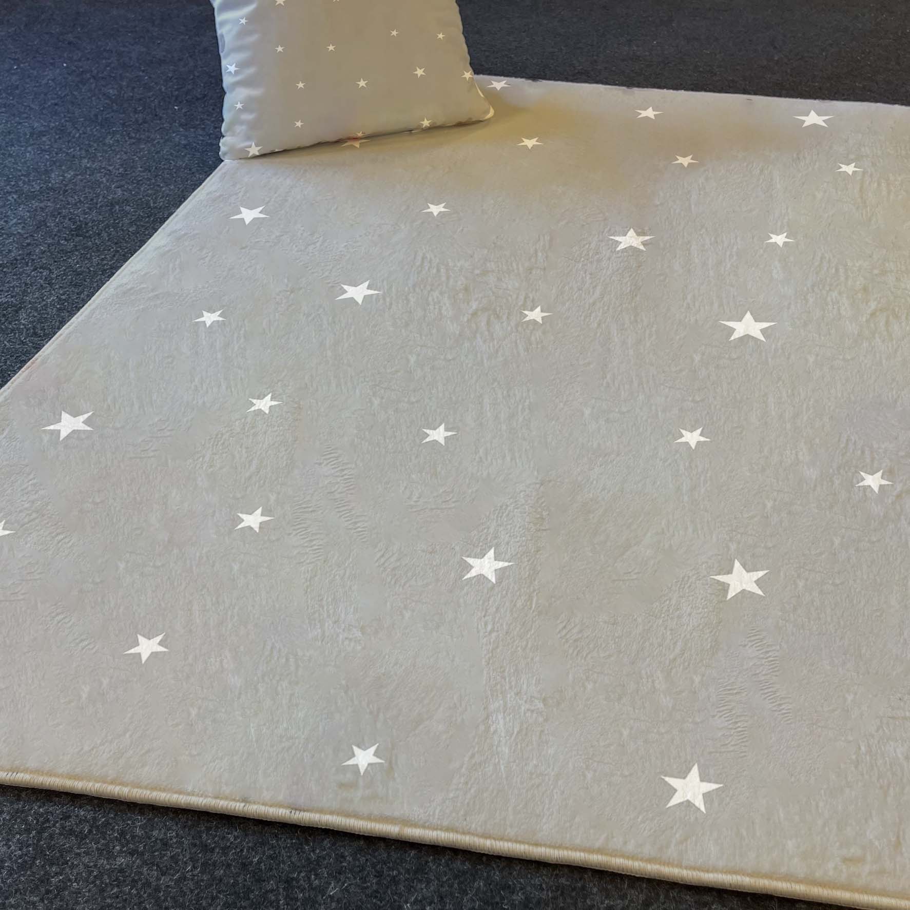 Pratik kullanıma uygun yıldızlı gri çocuk odası halısı, üzerinde beyaz yıldız desenleriyle minimalist bir tarz sunuyor. Rahat bir oturma alanı için ideal.